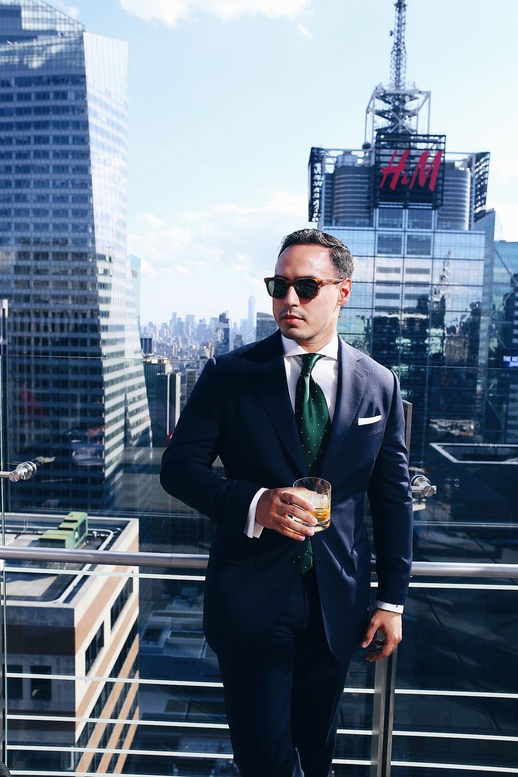Navy suit with a green tie on a Manhattan rooftop
